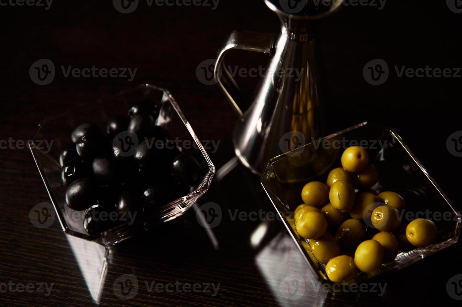 Elegant display of black and green olives with a silver oil jug photo