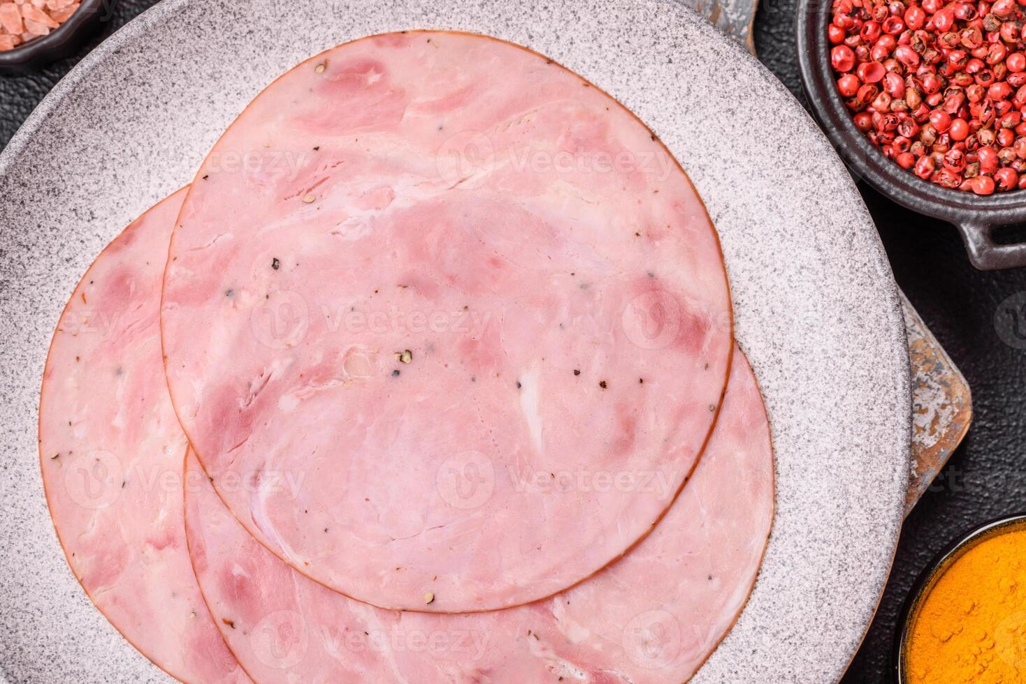 Smoked ham with salt, spices and herbs cut into round slices photo