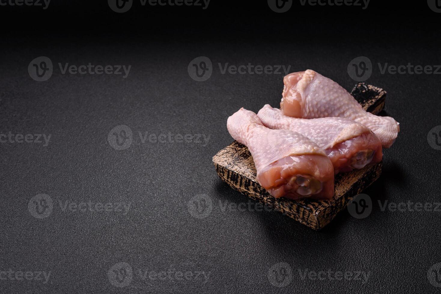 Raw chicken legs with salt, spices and herbs photo