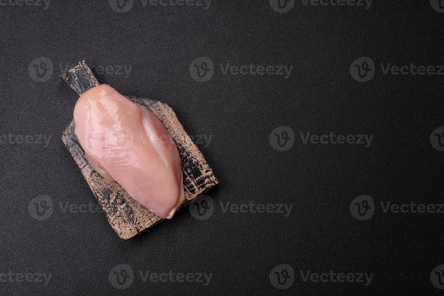 Pieces of raw chicken or turkey fillet with salt, spices and herbs photo