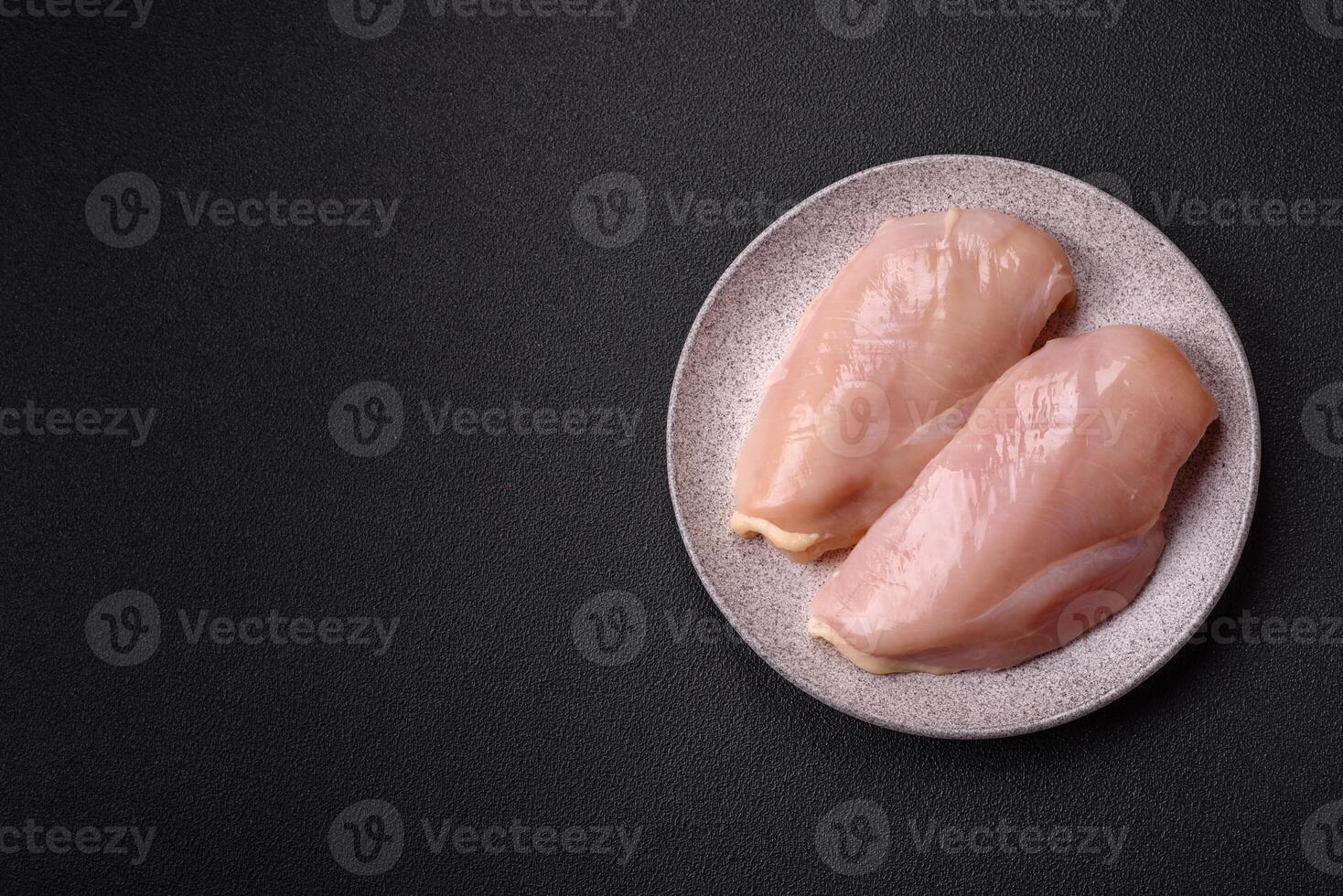 Pieces of raw chicken or turkey fillet with salt, spices and herbs photo