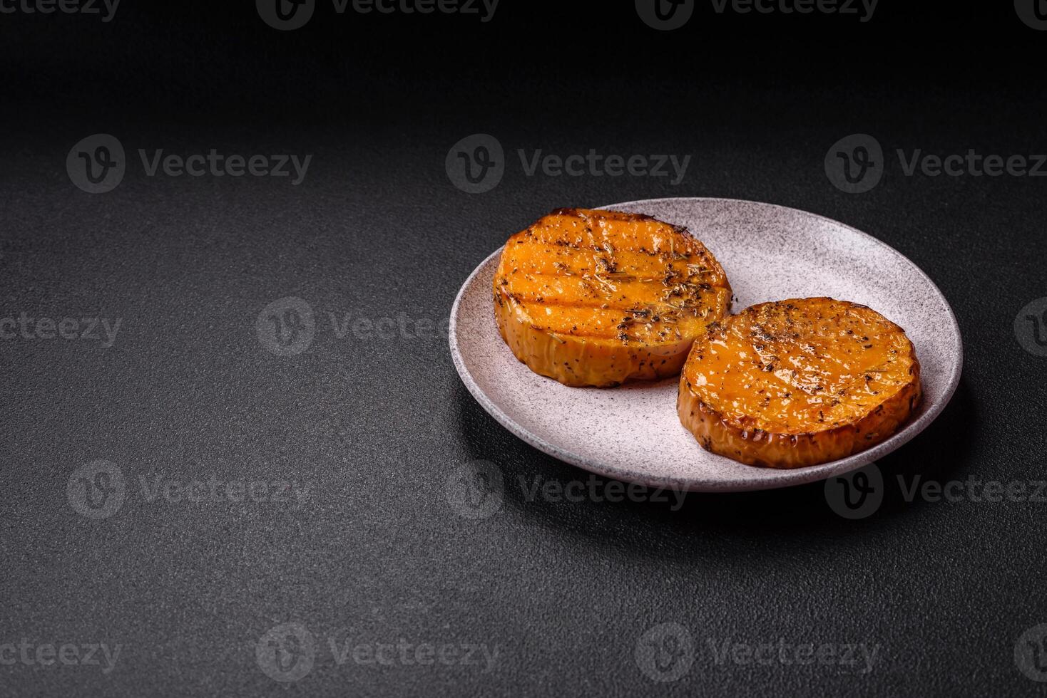 Pumpkin cut into slices and grilled with rosemary and spices photo
