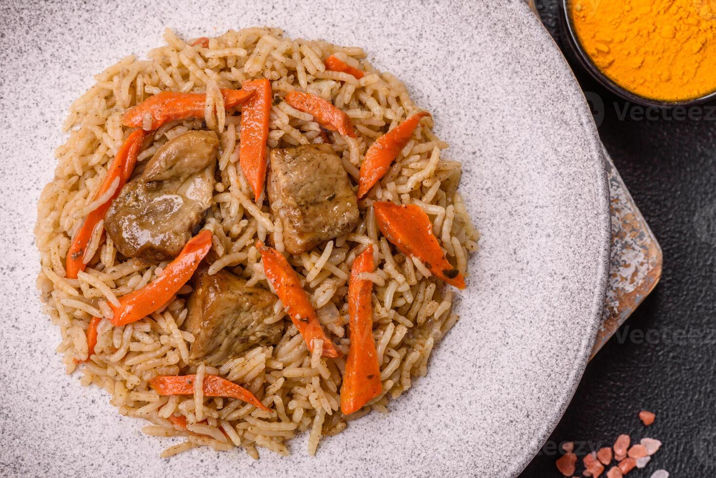 Delicious fresh pilaf with rice, carrots, meat, onions, spices and berries photo