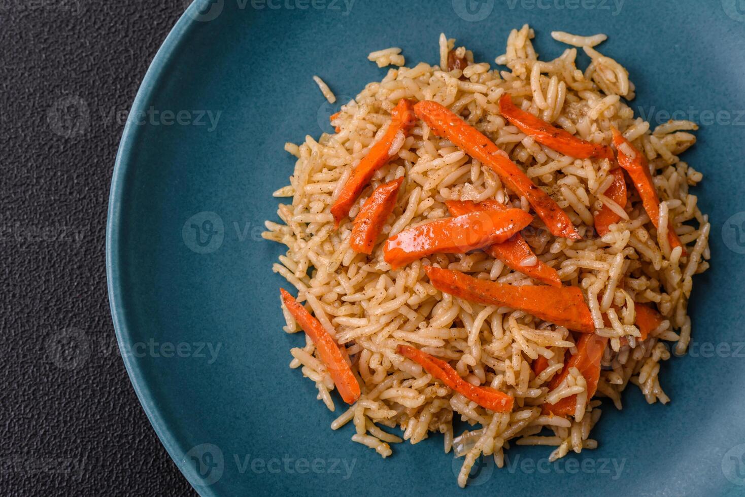 Delicious fresh pilaf with rice, carrots, meat, onions, spices and berries photo