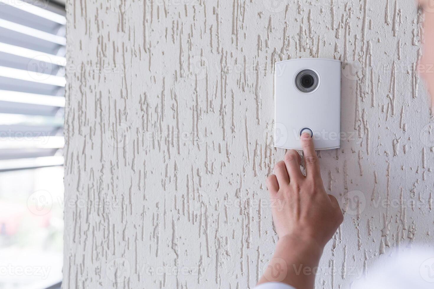 Close-up photo. The finger of a man's hand presses the button of the incoming call of the door, the camera. Electric lock to office, home, delivery. photo