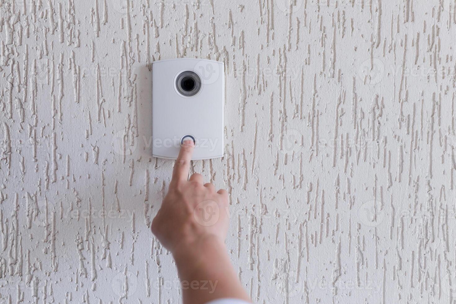 Close-up photo. The finger of a man's hand presses the button of the incoming call of the door, the camera. Electric lock to office, home, delivery photo