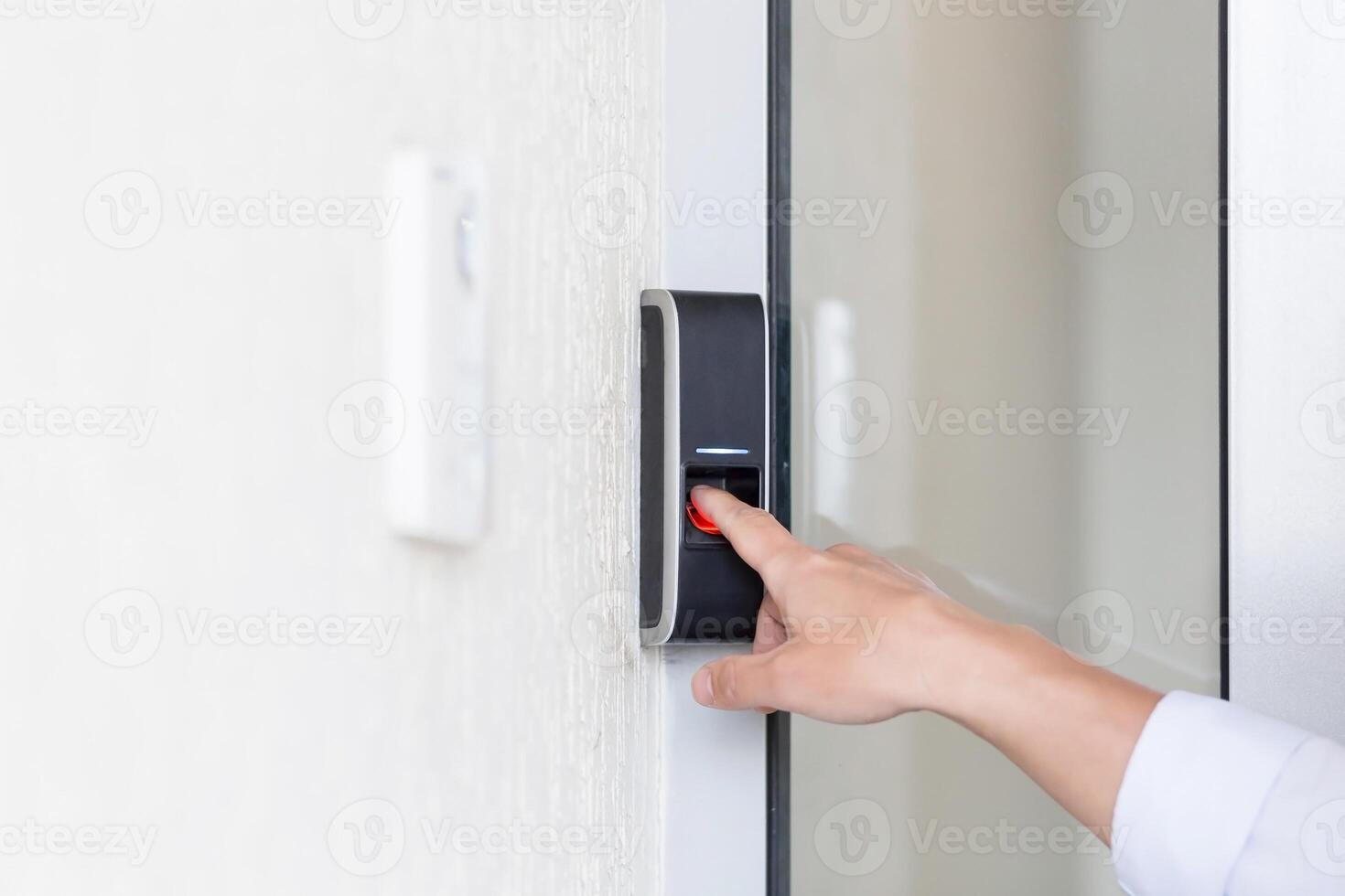 Asian businessman's hand using fingerprint sensor door lock, modern doorbell with camera. photo