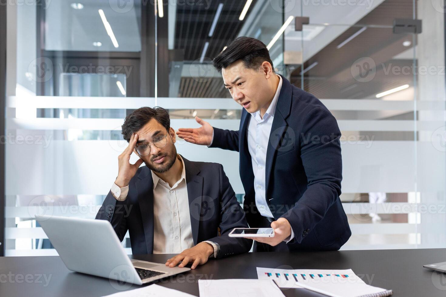 A frustrated employee is scolded by his boss during a tense office meeting. The interaction highlights workplace stress and conflict, embodying a common business scenario in a corporate environment. photo