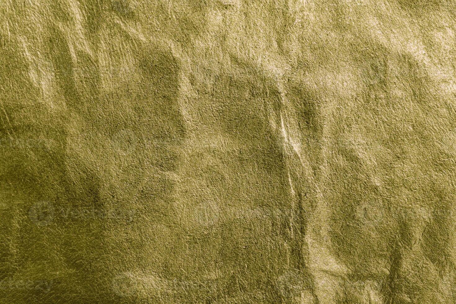 Close-up of gold wrinkled texture with visible grain, ideal as a background for design or abstract concepts. photo