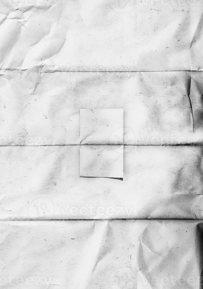 A black and white texture of folded and wrinkled paper with visible creases and subtle stains, perfect for artistic backgrounds or design overlays. photo