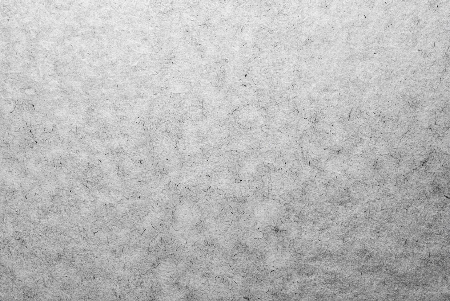 Close-up of a light paper surface featuring subtle fibers and natural imperfections, ideal for creative designs. photo
