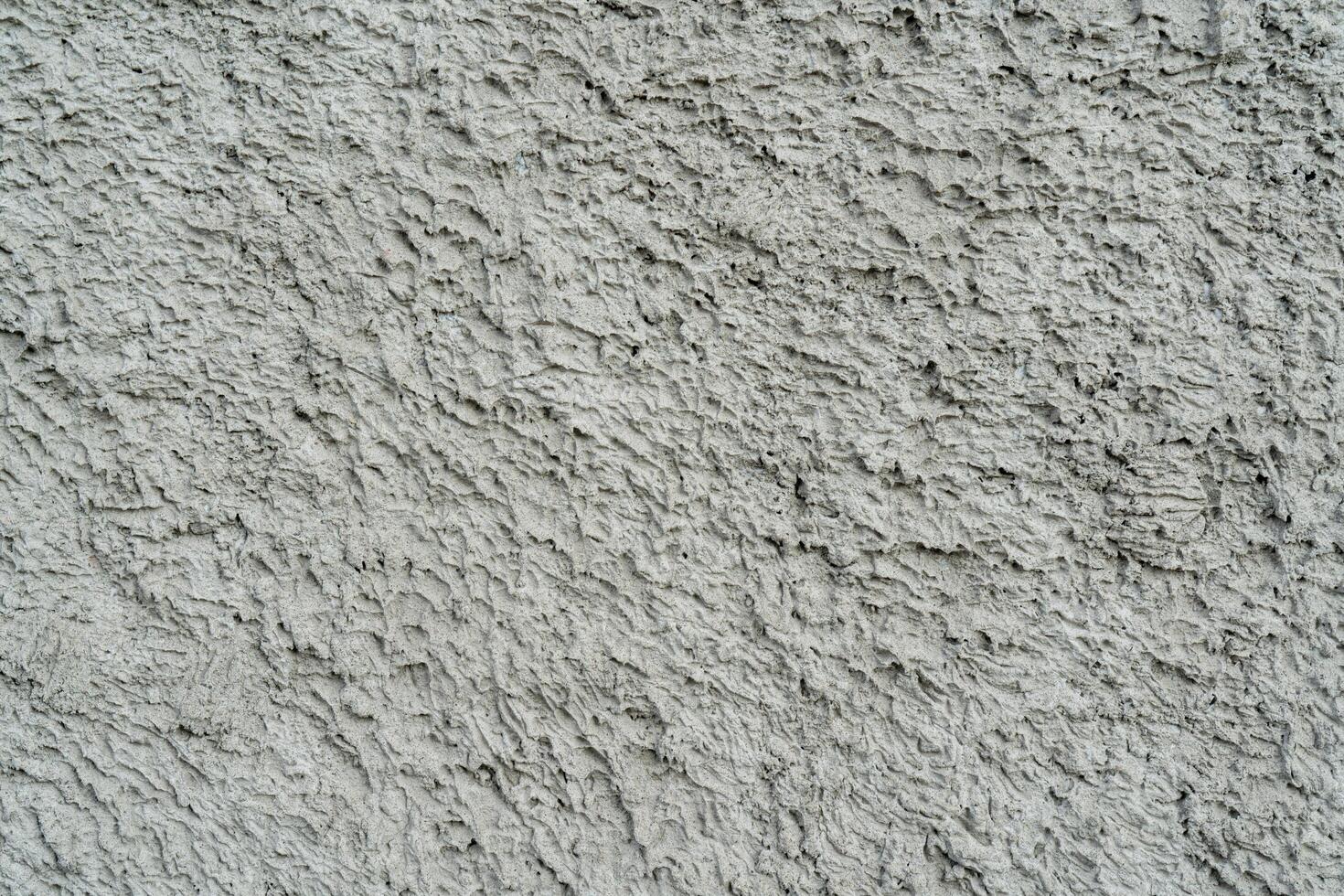 Gray texture of uneven plaster on the wall of the house. photo
