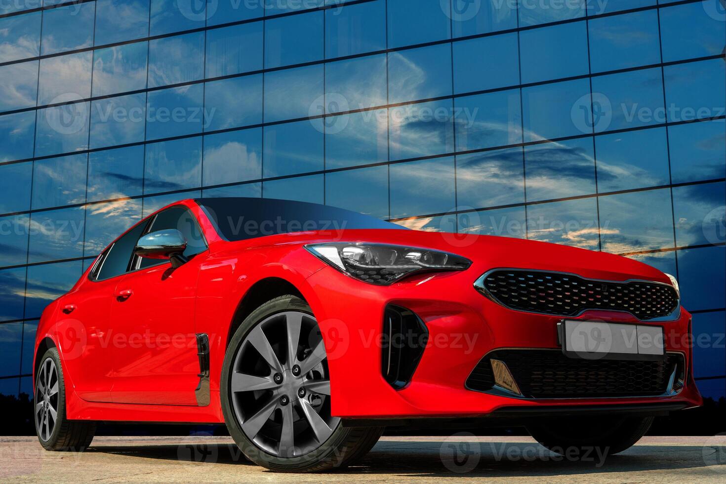 Red car against the background of the evening sky. Stylish, modern, bright image of the car for design solutions. photo