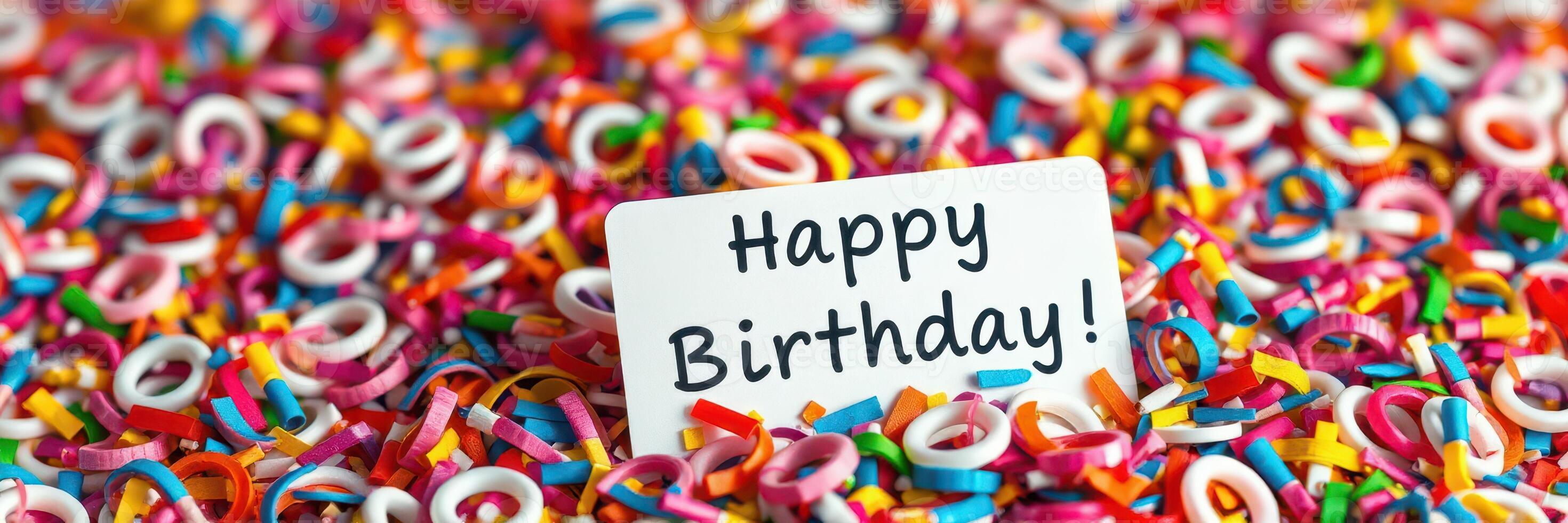 Colorful birthday celebration with sprinkles and a greeting card on a vibrant background of decorations photo