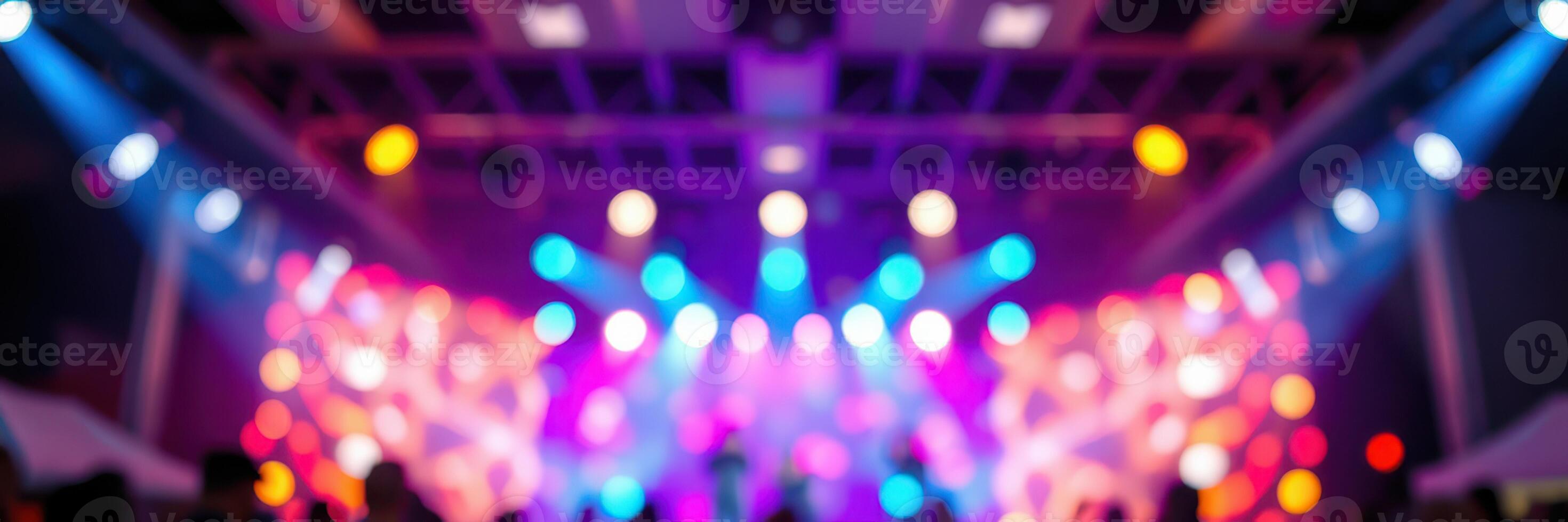 Colorful lights illuminate a lively music event at an indoor venue during the evening photo