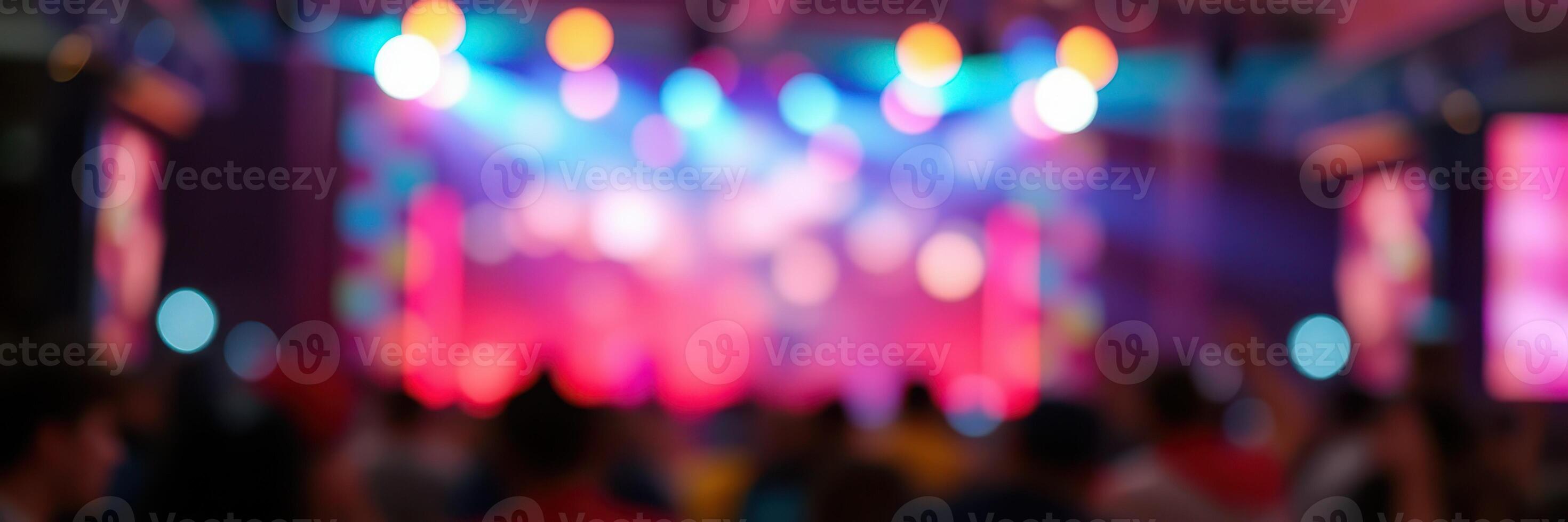 Colorful lights illuminate a vibrant concert atmosphere filled with excited fans and dynamic performances in an indoor venue photo