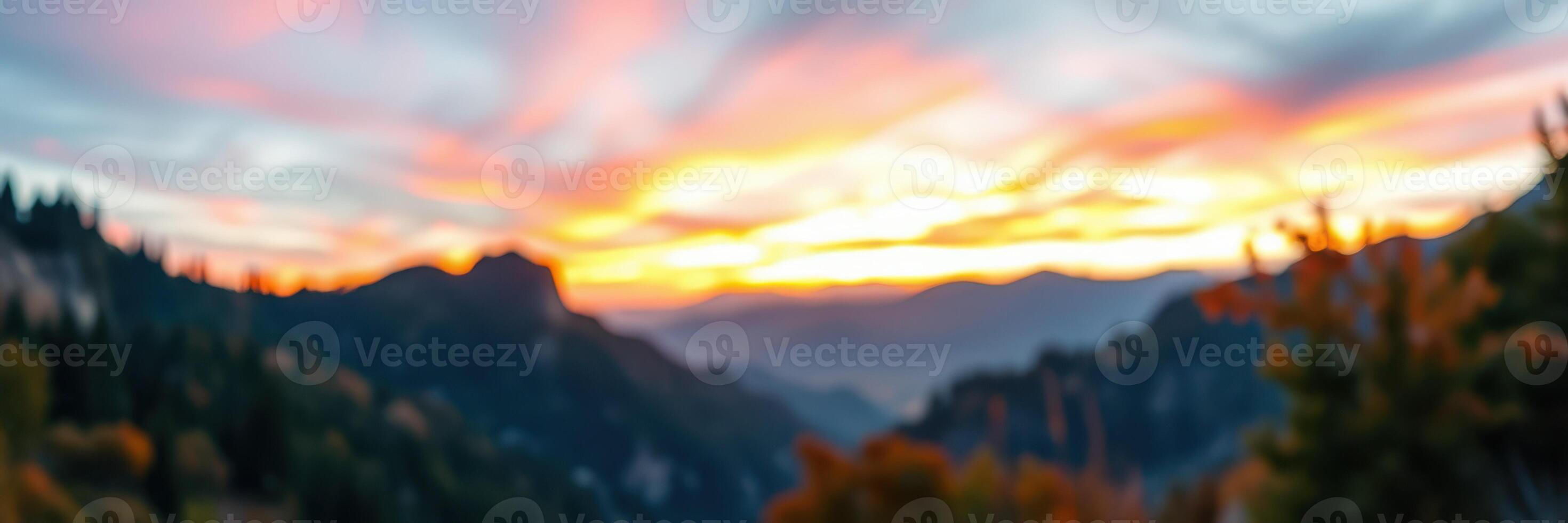 Vibrant sunset over a mountain landscape with soft clouds and warm colors filling the sky photo