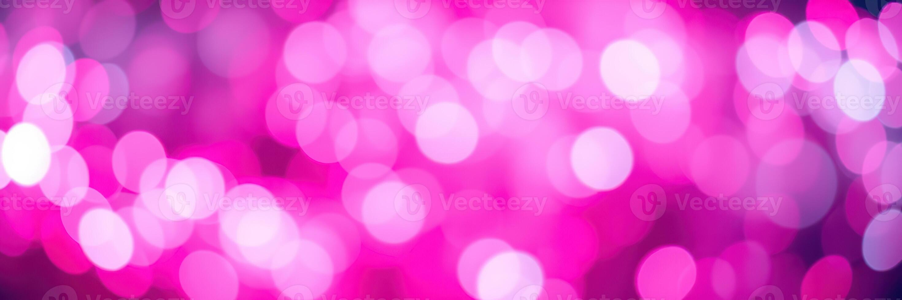Vivid pink bokeh lights create an enchanting atmosphere during a nighttime celebration in an urban setting photo