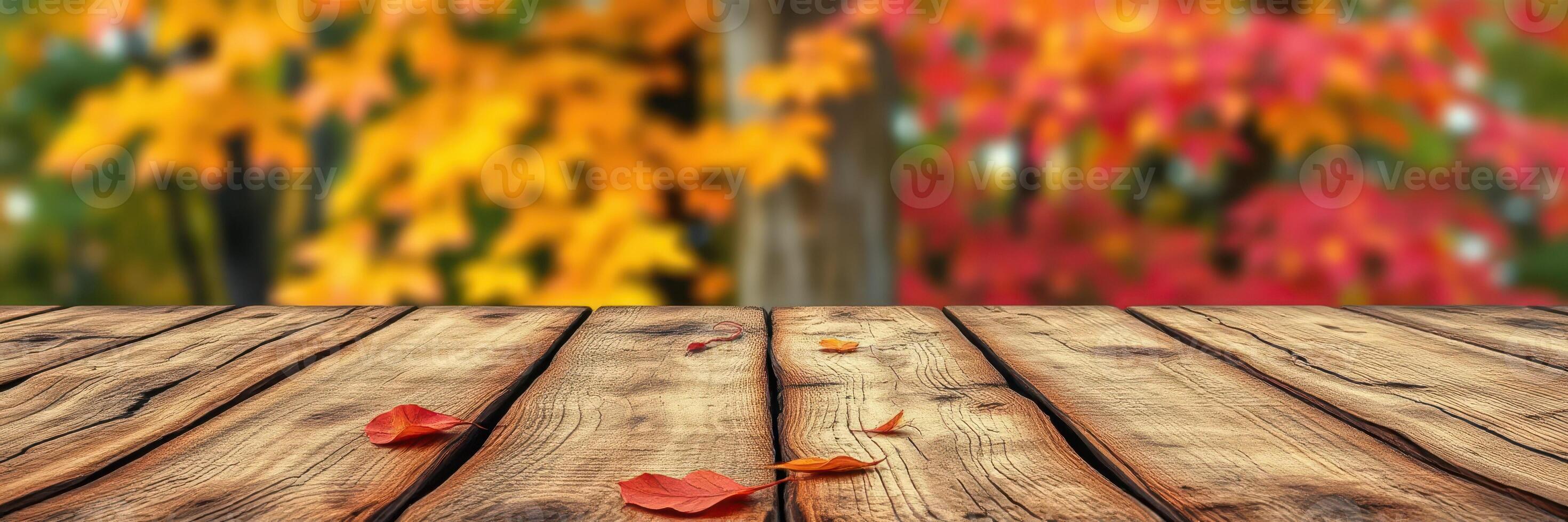 Vibrant autumn leaves create a colorful backdrop for a wooden tabletop in a serene outdoor setting during fall photo
