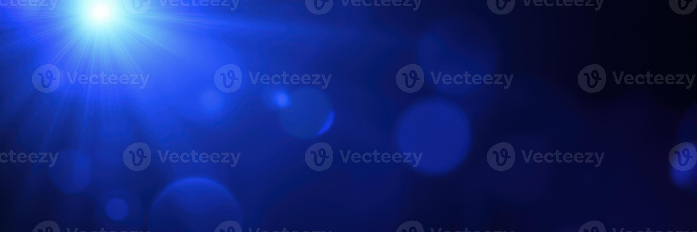 Vibrant blue light creates an ethereal atmosphere in a dimly lit space filled with floating particles photo
