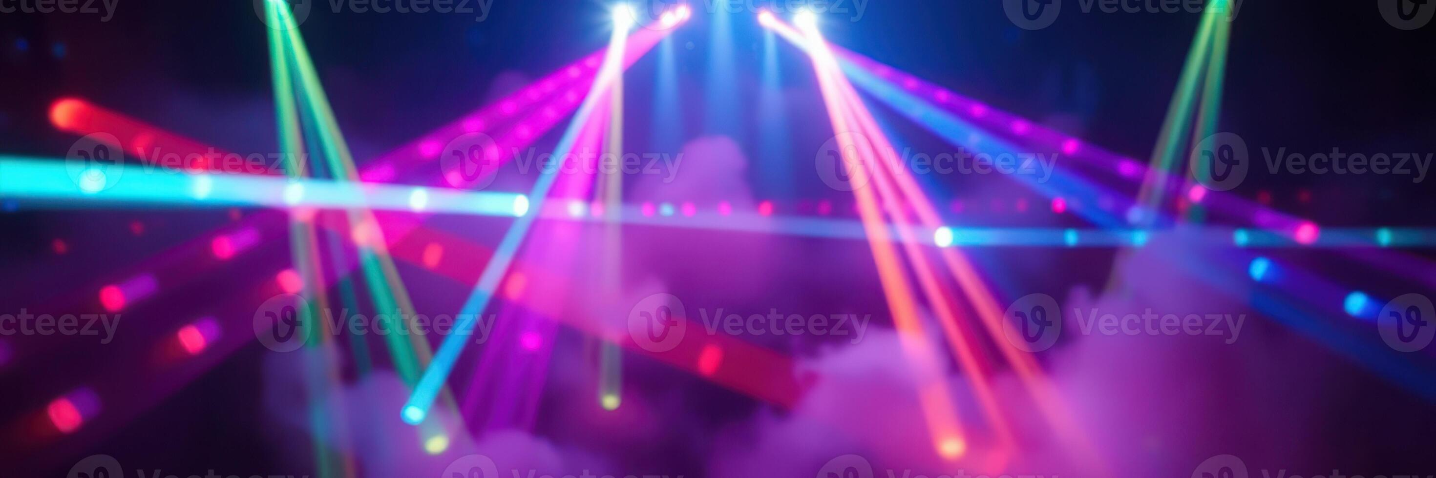 Colorful laser lights dance over a smoke-filled stage during a vibrant music event in a concert hall photo