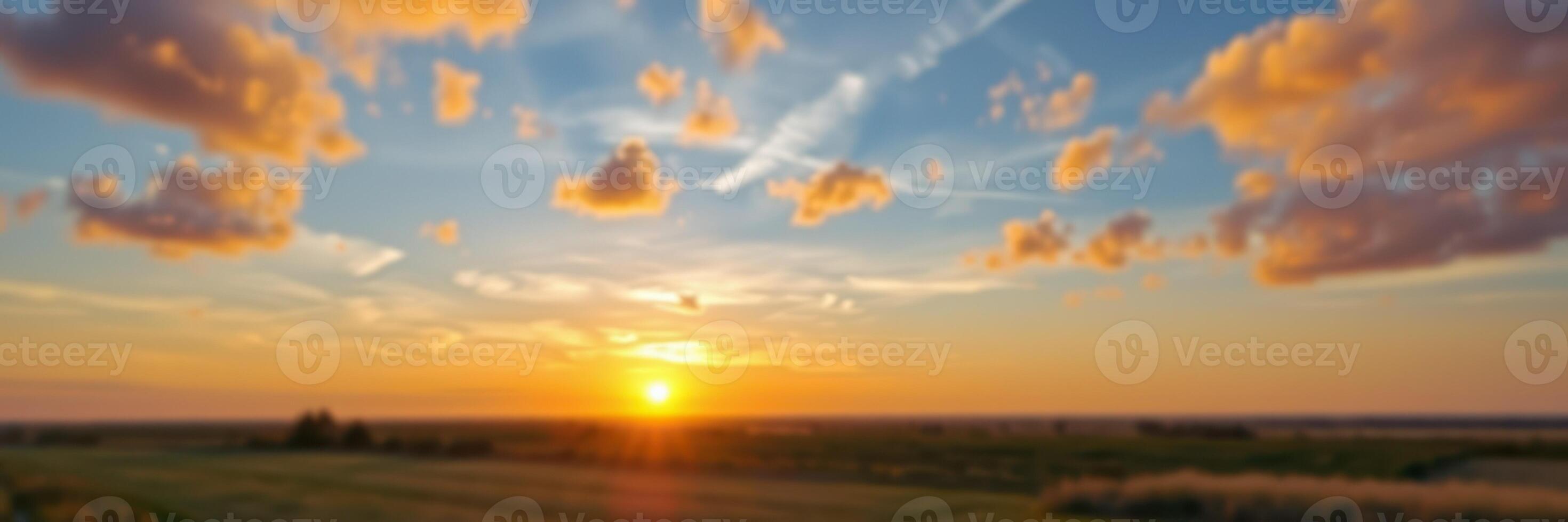 Sunset over an open field with colorful clouds and a serene atmosphere in the early evening photo