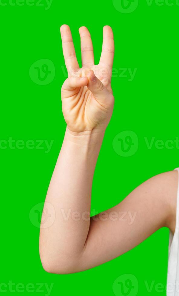 A hand showing the number three against a bright green background photo