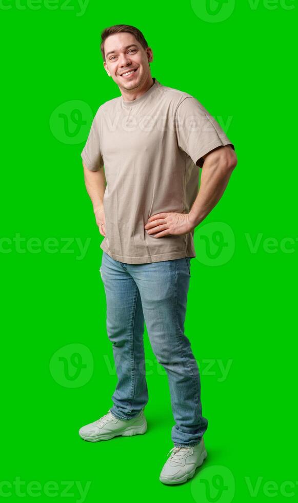 A young man stands confidently in casual attire on a vibrant green background photo