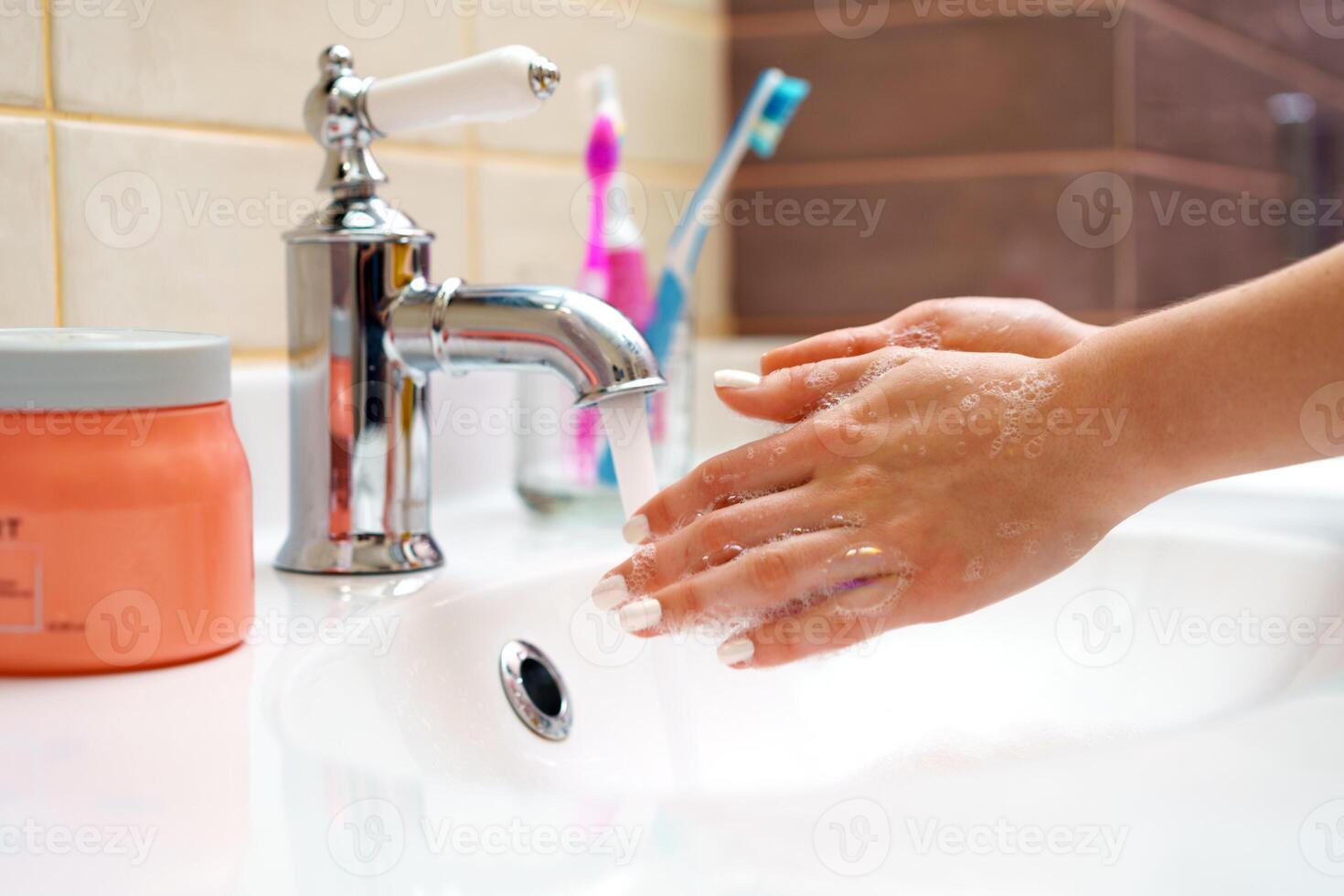 Woman washing her hands with soap close up photo