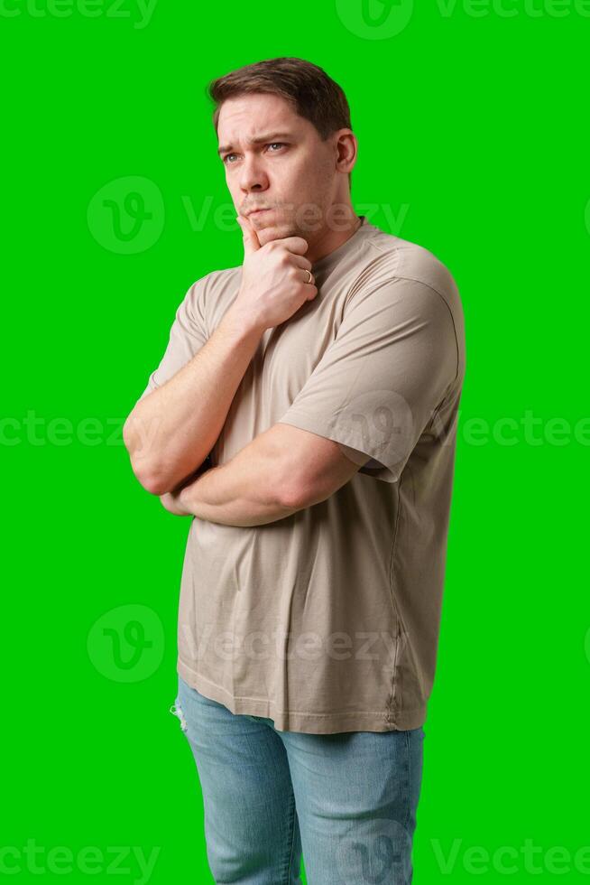 Thoughtful man gestures against a green background photo
