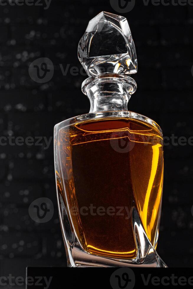 Whisky bottle close up against black grunge wall photo