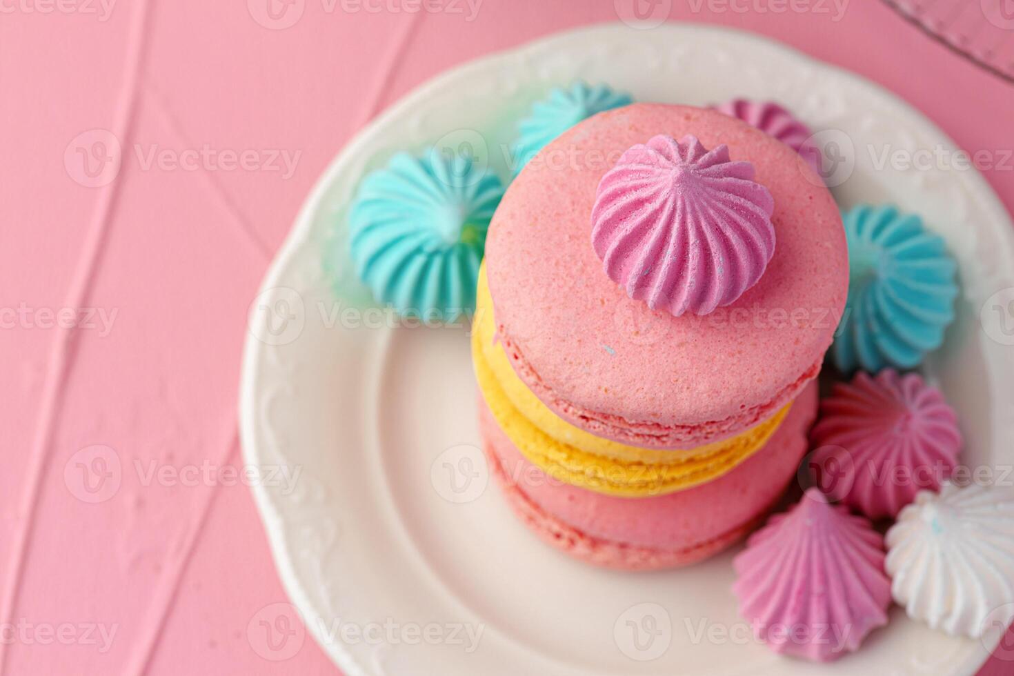 French macaroon cookies of bright colors served in white ceramic plate photo