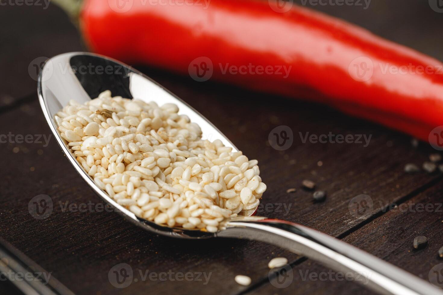 Spoon with spices on dark wooden table close up photo