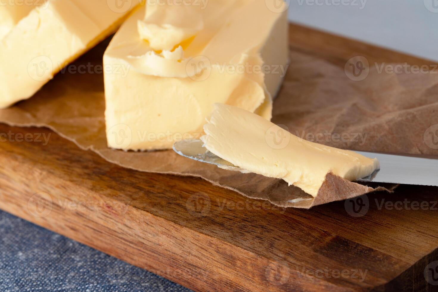 Wooden board with butter on blue checkered napkin photo