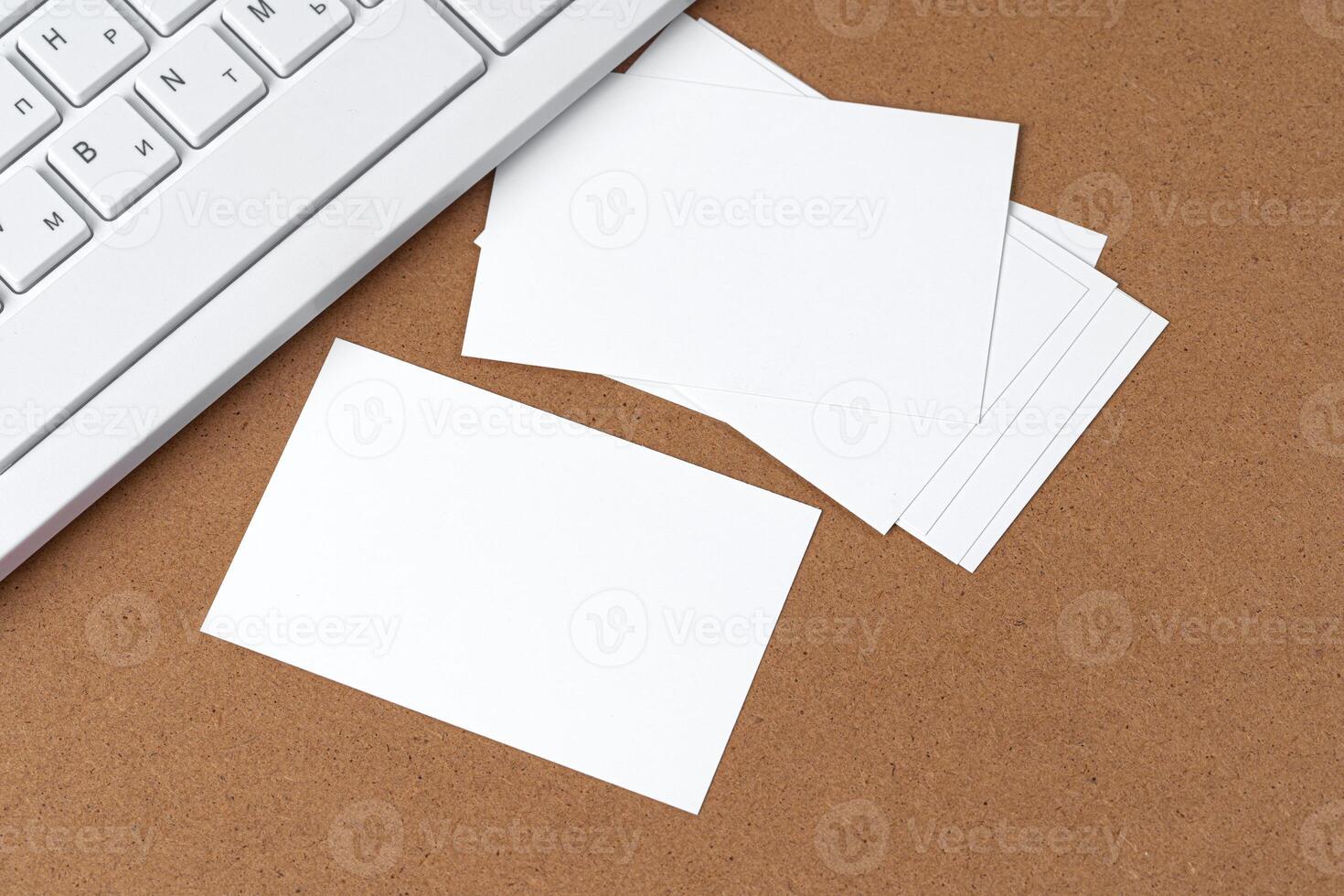 Blank business cards with supplies and keyboard on office table. photo