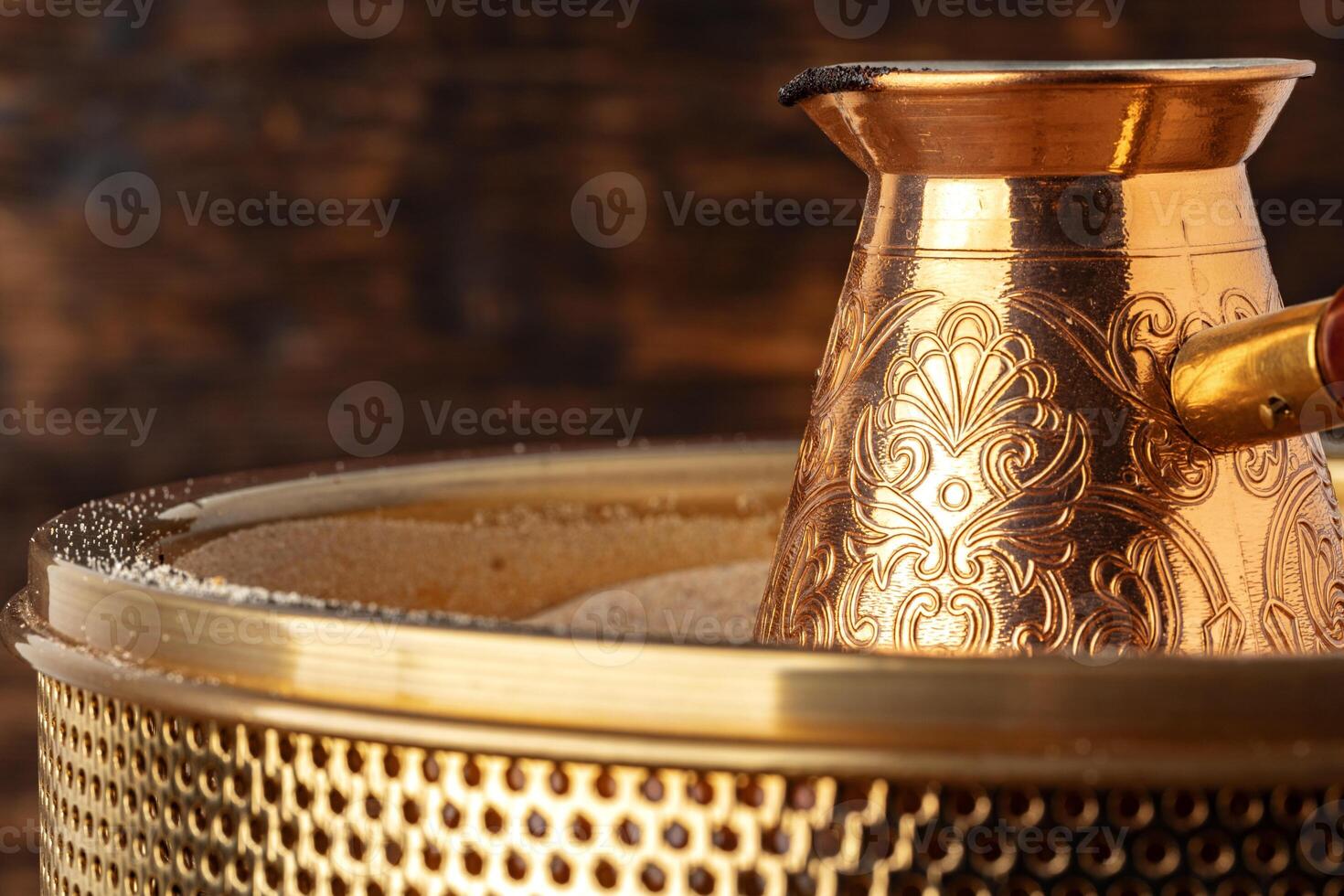 Turkish coffee in cezve on the sand photo