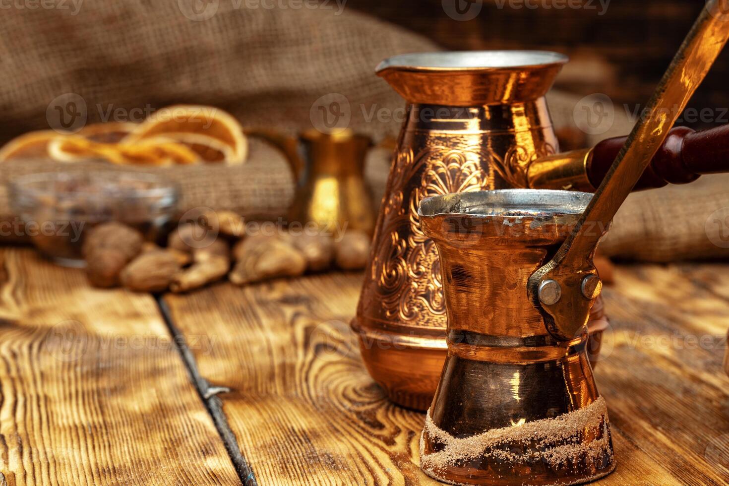 Shiny copper turk with brewed coffee on brown wooden table photo