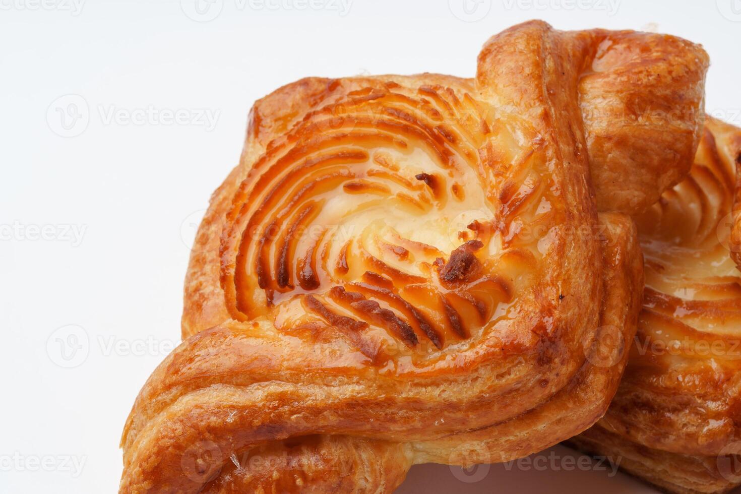 Freshly baked danish pastry with golden layers and sweet filling on a clean surface photo