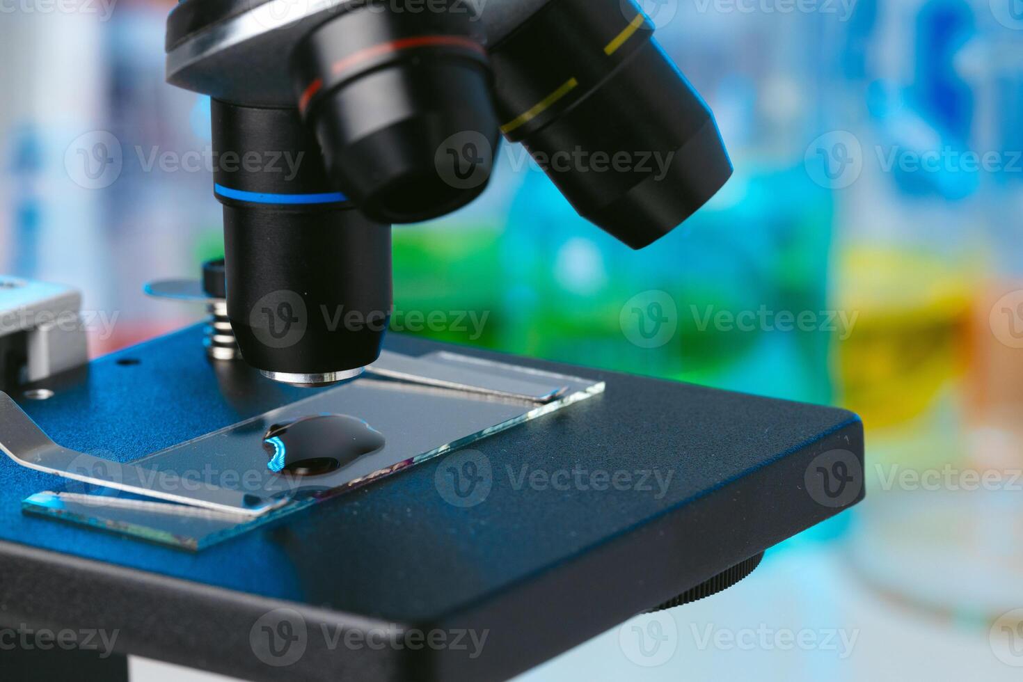 Scientific laboratory with microscope and test tubes with samples, close up photo