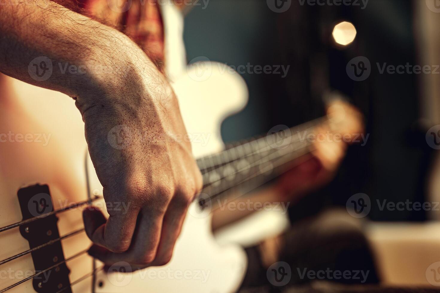 Close up of male hand playing electric guitar in the dark photo