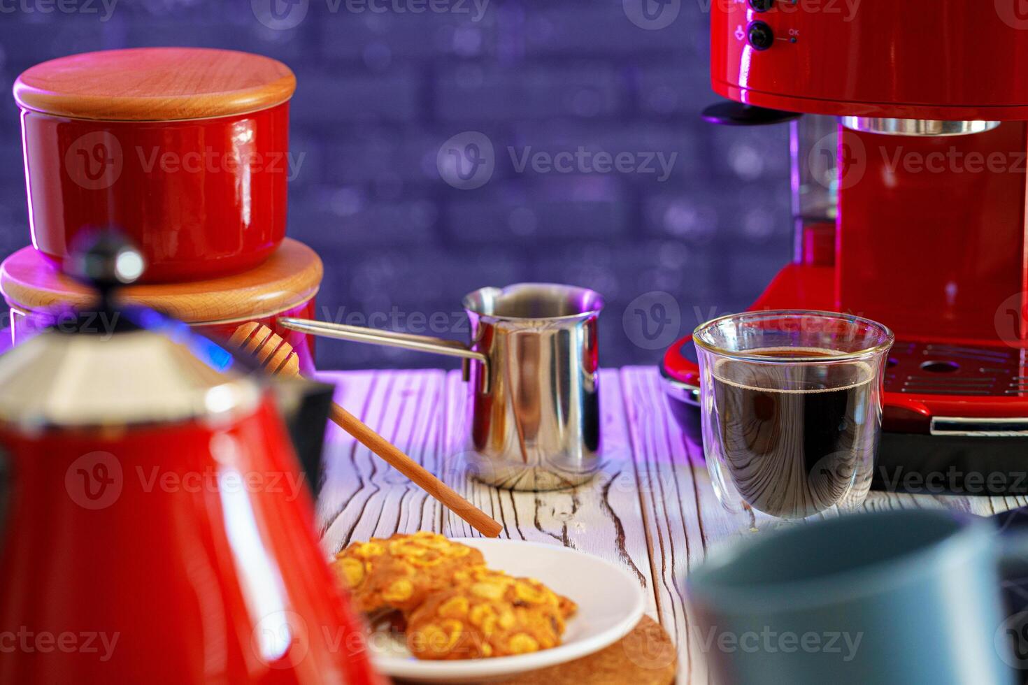 Wooden honey dipper on kitchen table with kitchenware photo
