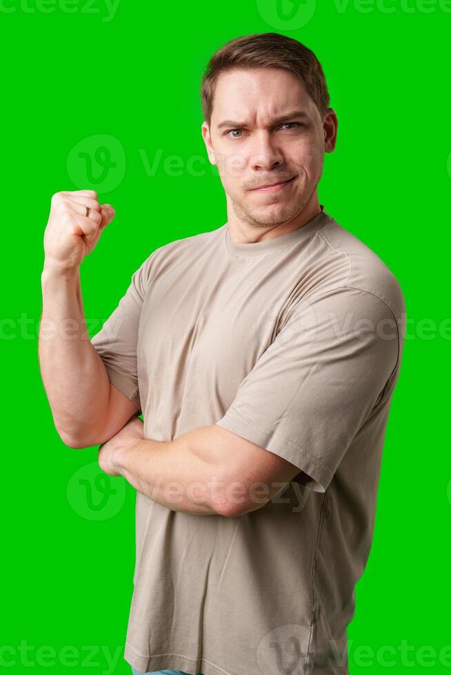 Man celebrating with a confident smile and raised fist against a bright green background photo