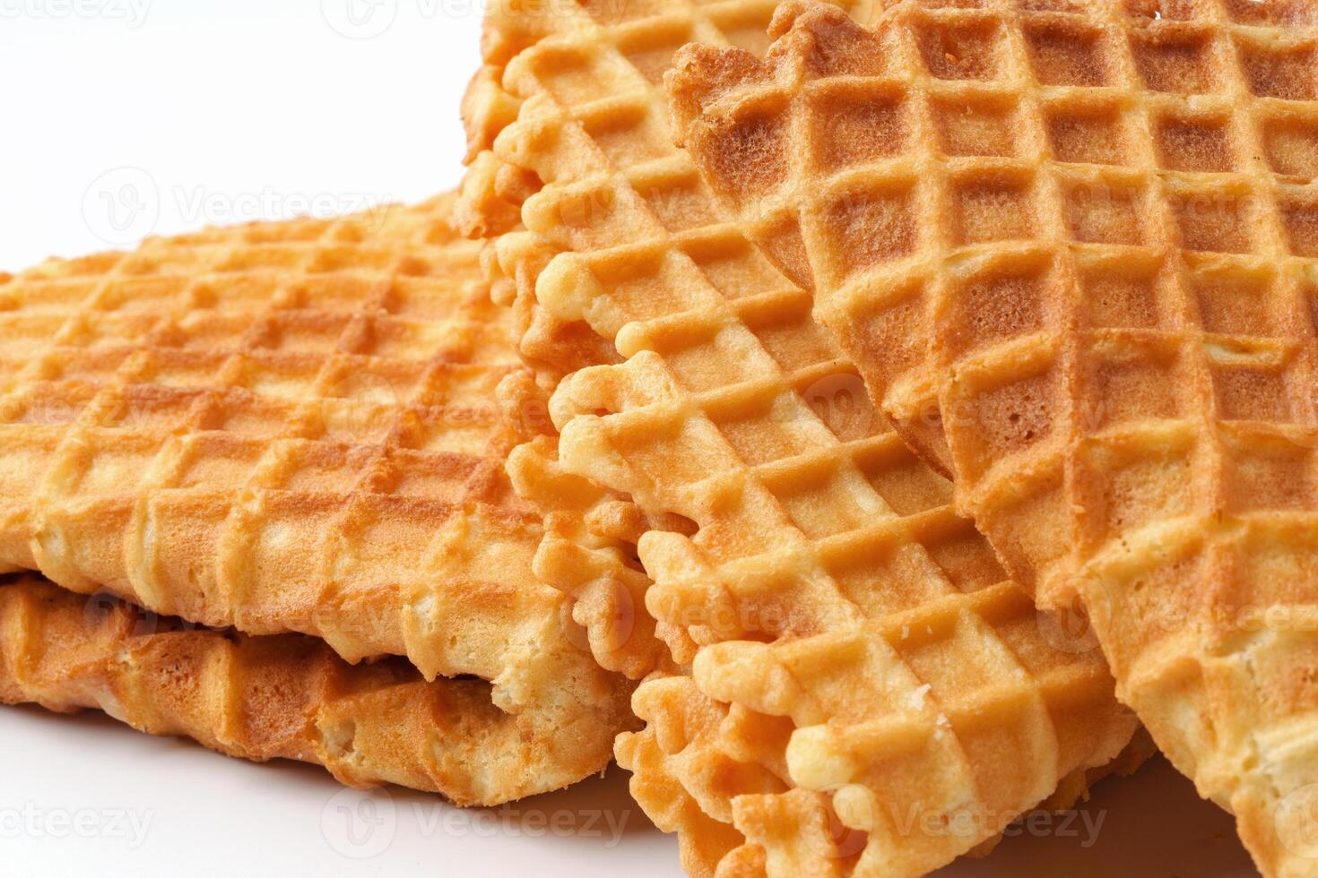 Crispy waffle texture displayed on a white background with multiple layers of golden-brown treats stacked together photo
