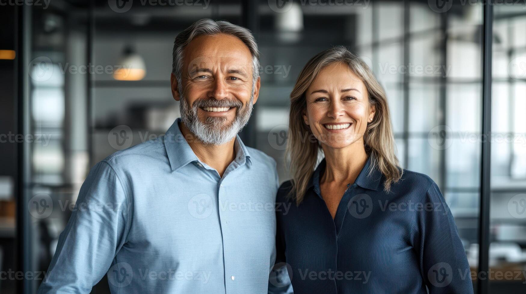 A couple stands in a contemporary office, showing joy and connection while smiling at the camera photo