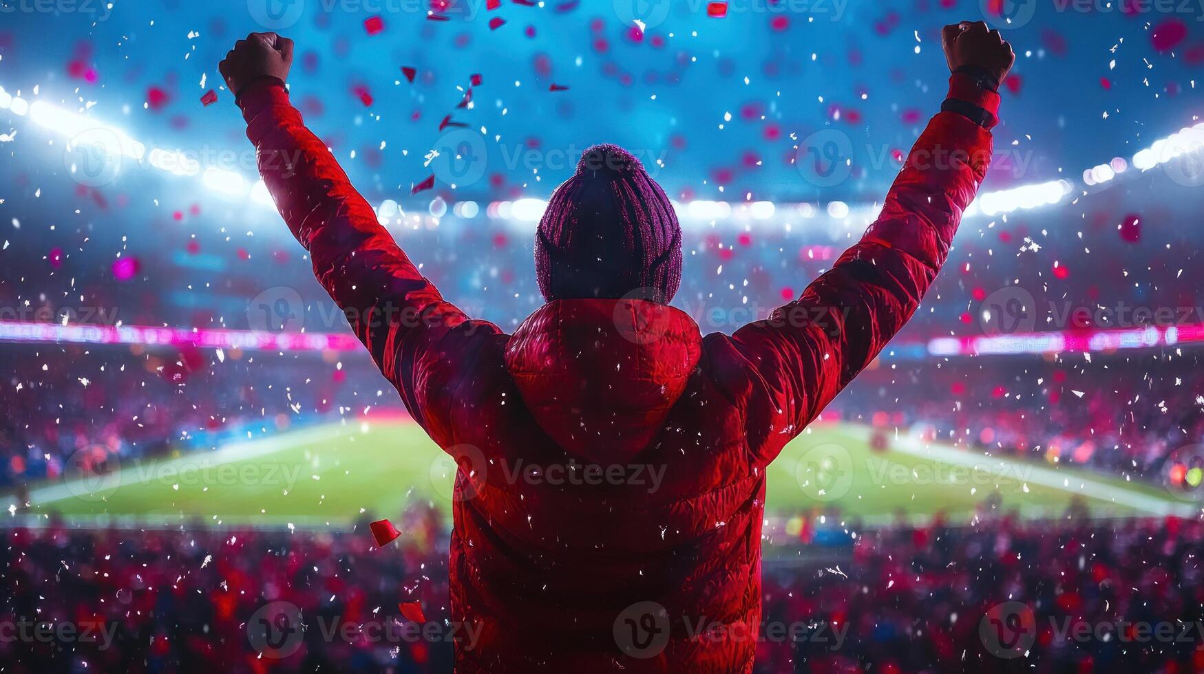 Crowd cheers as a fan raises arms in joy amid colorful confetti during a thrilling football match photo