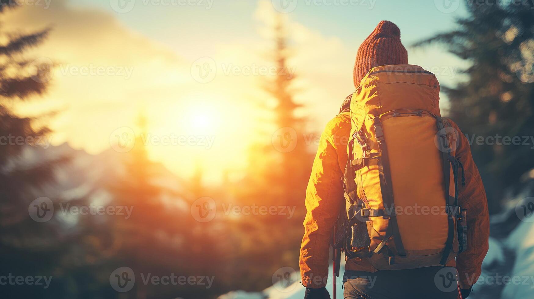 A hiker stands with a backpack, enjoying the breathtaking sunrise in a serene mountain setting photo