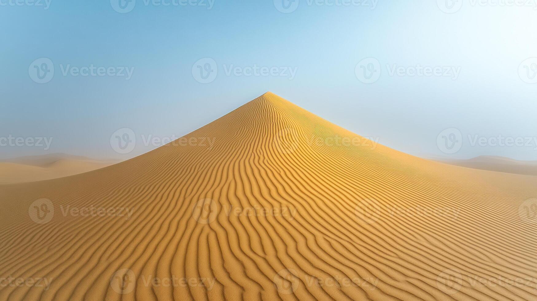 A vast sand dune stands tall under bright blue skies, showcasing intricate patterns and textures photo