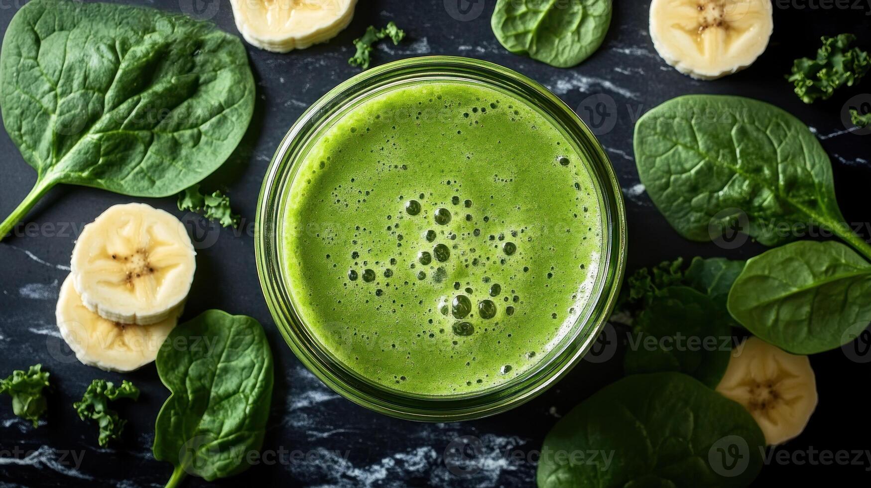 A vibrant green smoothie sits in a jar, surrounded by banana slices and fresh spinach leaves photo