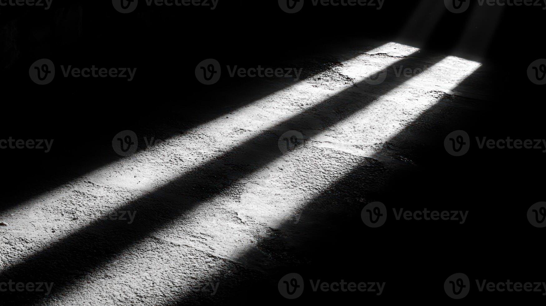 Sunlight streams through, creating stark shadows on an old stone floor photo