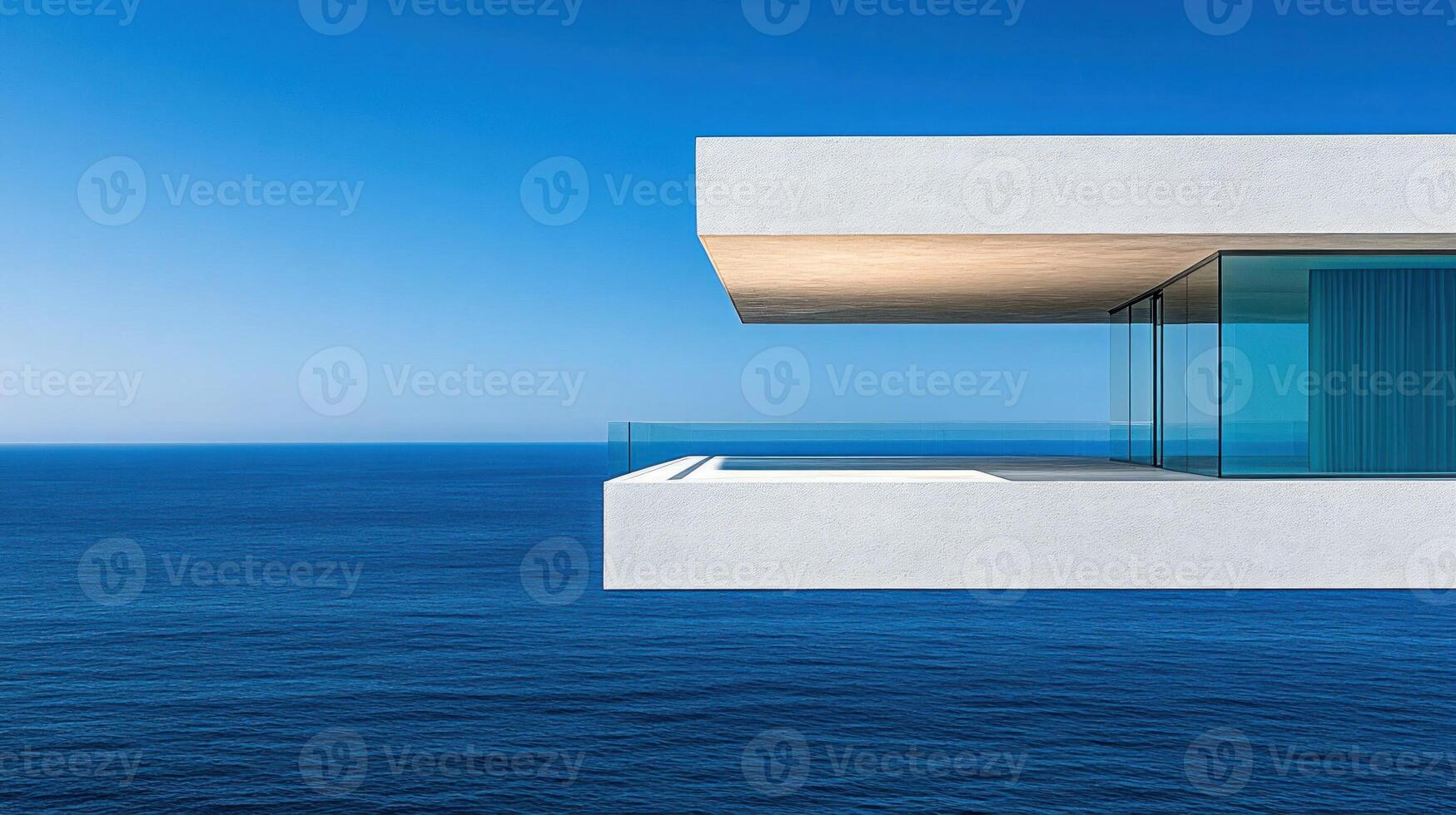 A unique building features a sleek balcony overlooking a calm blue ocean, inviting relaxation photo